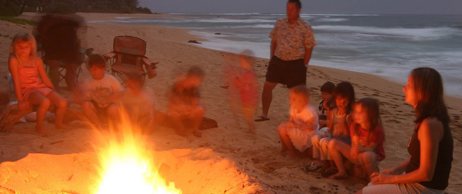 Family singalong at a beach campfire